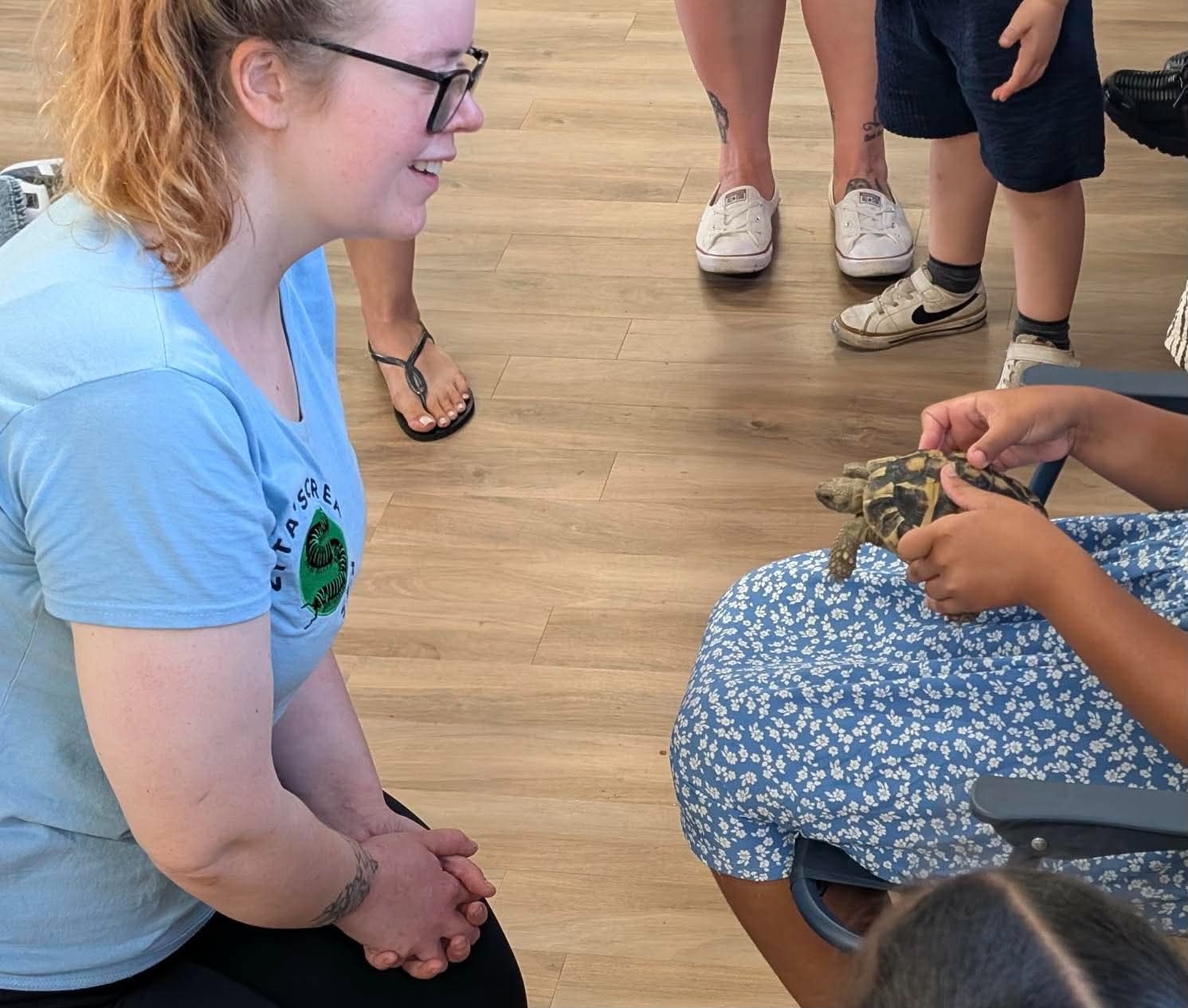 Zyta guiding a close-up animal encounter with a visitor